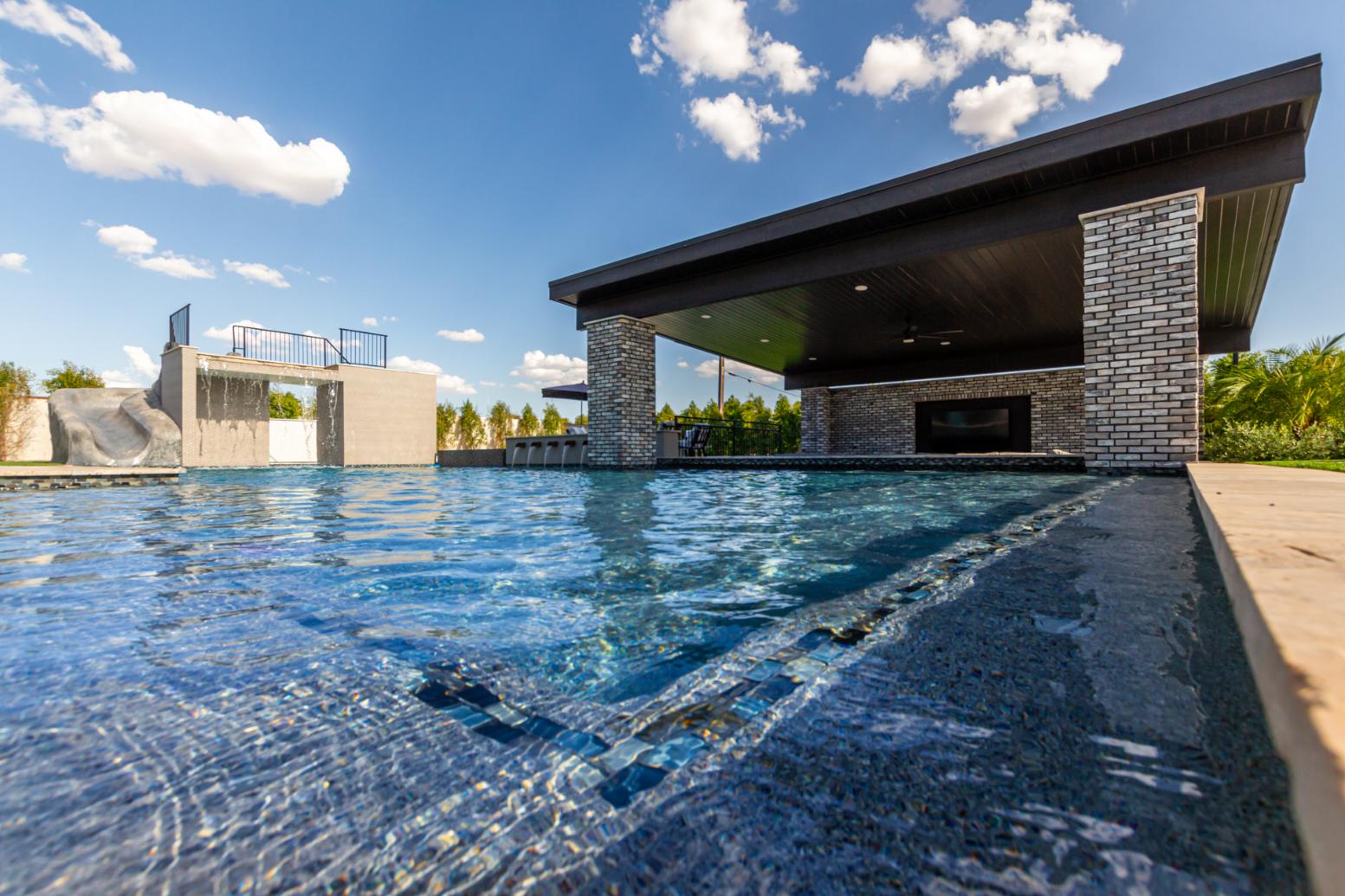 Custom pool with waterfall feature and surrounding landscape design